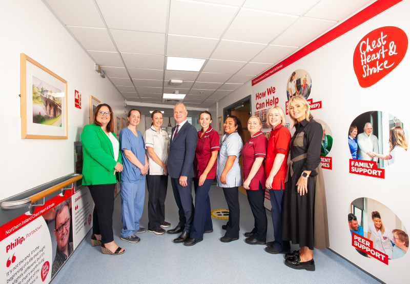 <p>Ursula Ferguson, NICHS Head of Care Services (Far left), NICHS CEO Declan Cunnane (4th from left) and Noelene Hughes, NICHS Head of Stroke Services (far right) with staff from the stroke ward at Royal Victoria Hospital, Belfast, alongside the charity's 'Hall of Hope' on the ward.</p>